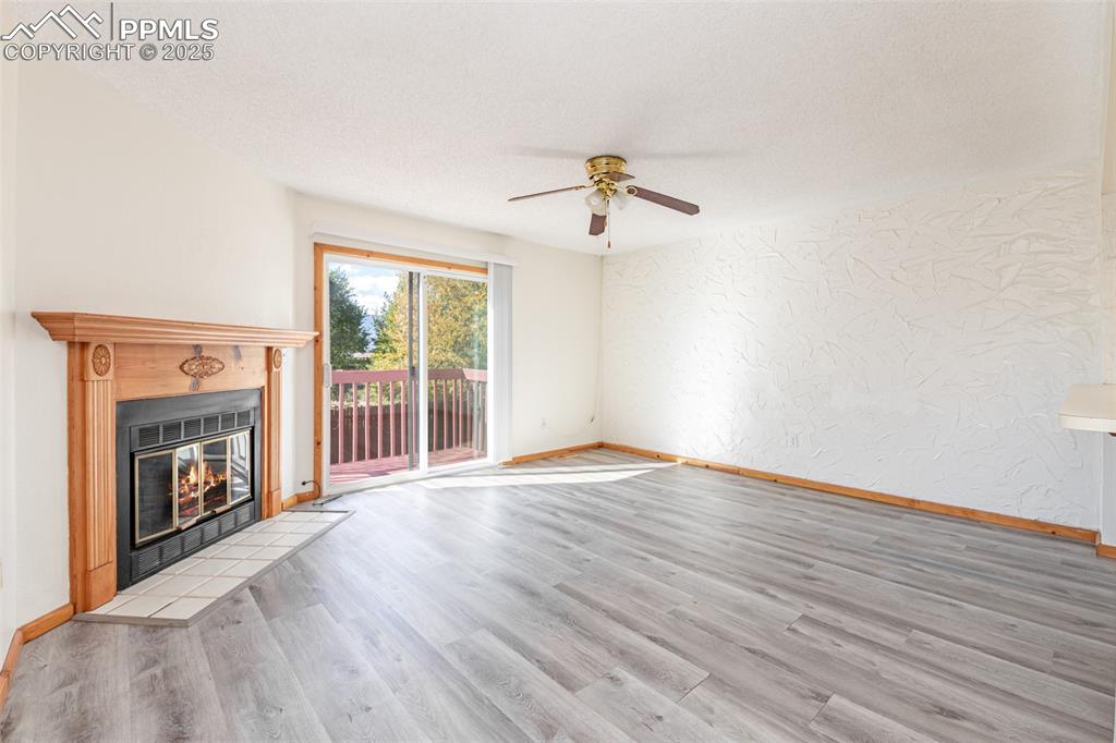 Image 6 of 31: Unfurnished living room featuring a textured wall, light wood finished floo