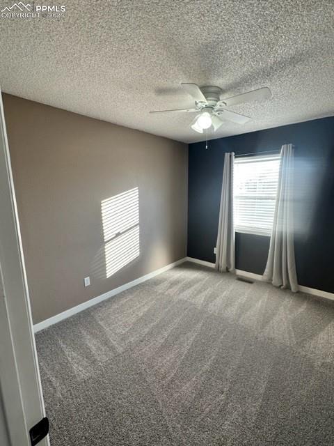 Image 13 of 24: Carpeted spare room with a textured ceiling and a ceiling fan