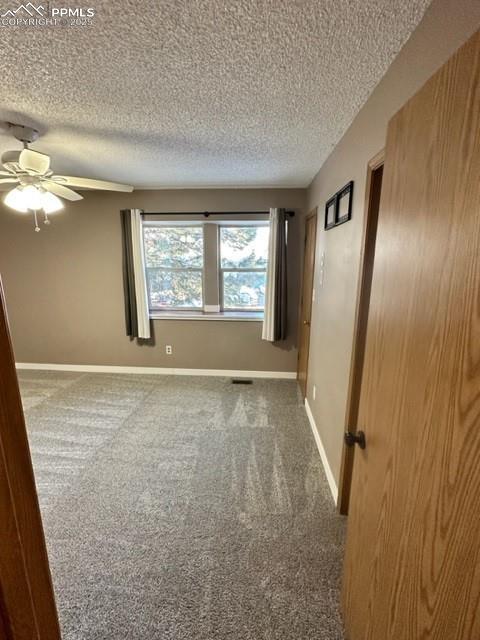 Image 18 of 24: Empty room with carpet flooring, a textured ceiling, and a ceiling fan