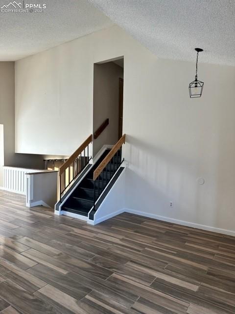 Image 2 of 24: Staircase featuring a textured ceiling and wood finished floors