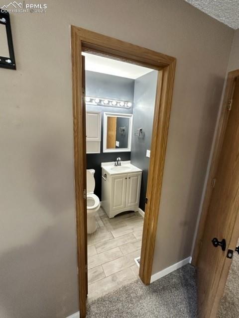 Image 22 of 24: Half bathroom featuring toilet and vanity