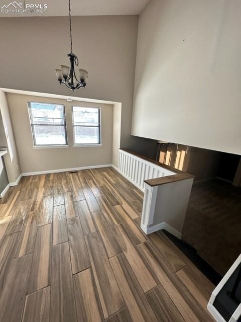 Image 5 of 24: Unfurnished dining area featuring a chandelier, dark wood finished floors, 