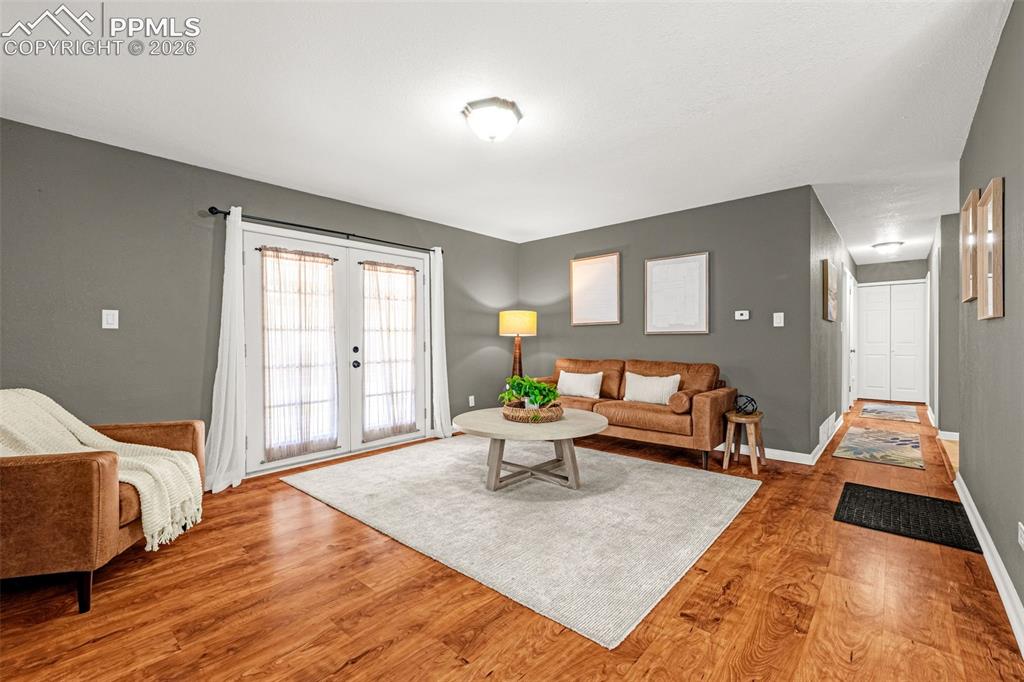 Image 8 of 21: French doors and wood floors in living room and hallway