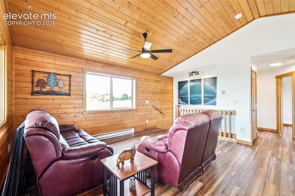 Image 13 of 33: Vaulted wood-paneled ceiling with a ceiling fan, complemented by wood-finis