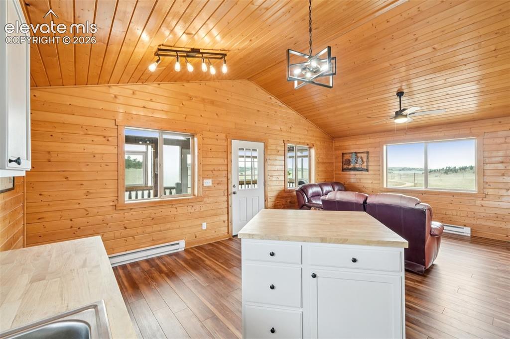 Image 14 of 33: Open-concept interior featuring wood-finish walls and vaulted wood-finish c