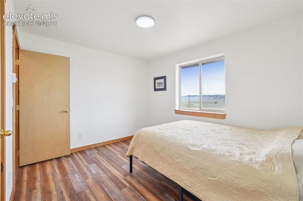 Image 26 of 33: Bright interior with wood-finish flooring, white walls, and a large window
