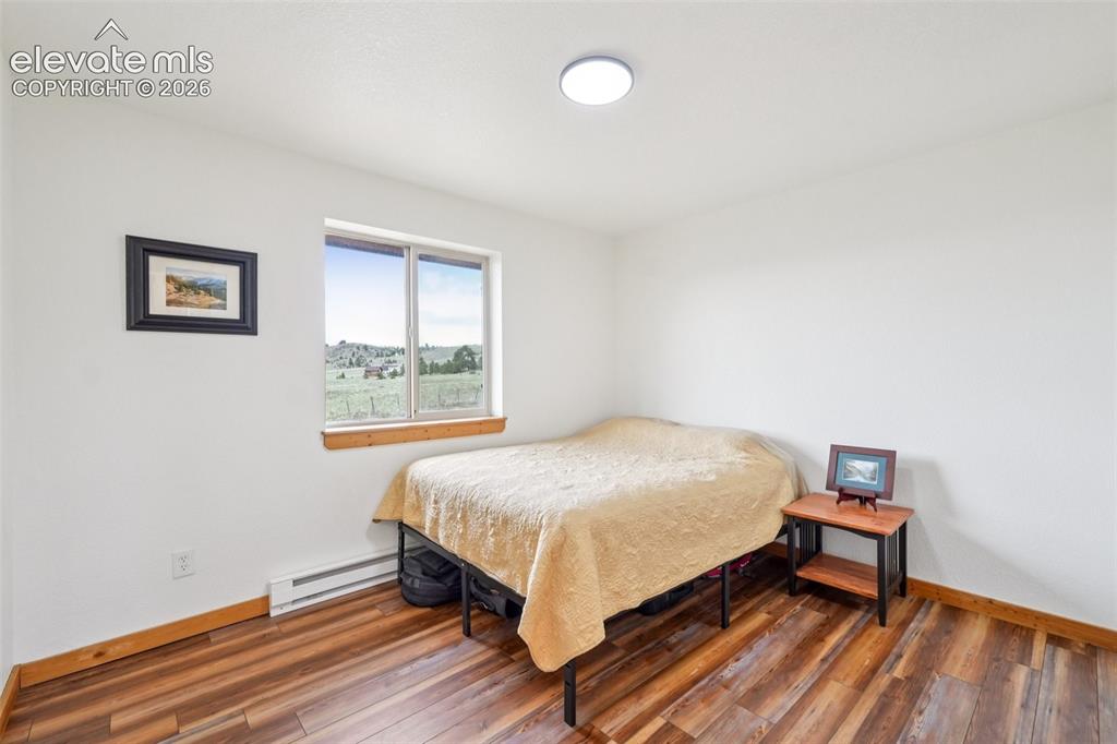 Image 27 of 33: Bright interior space featuring a window with a rural landscape, wood-finis