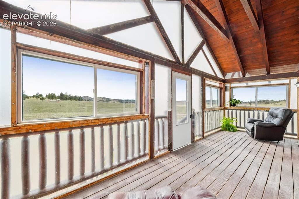 Image 29 of 33: Enclosed porch featuring wood-finish flooring, exposed wood beams, multiple