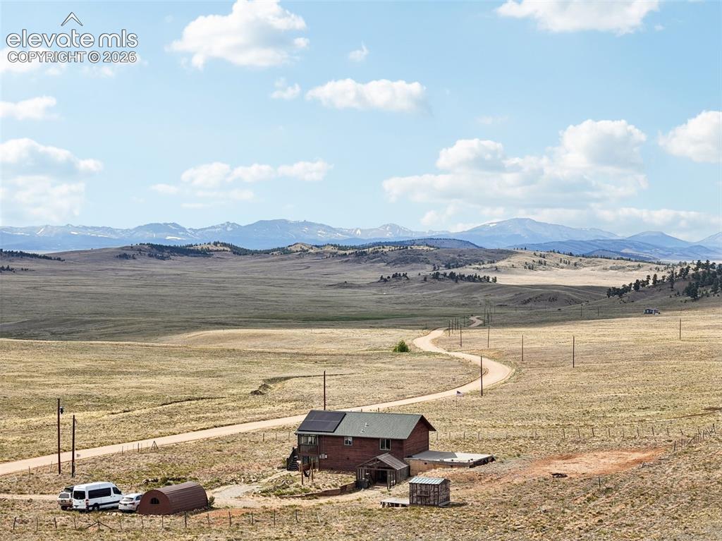 Image 32 of 33: Rural property featuring a single-story residence with a dark roof and visi