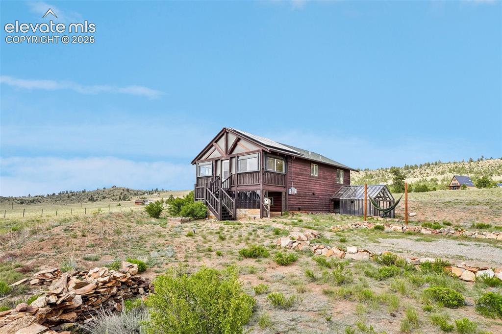 Image 4 of 33: Wood-sided residence featuring a front deck with open railing and an attach
