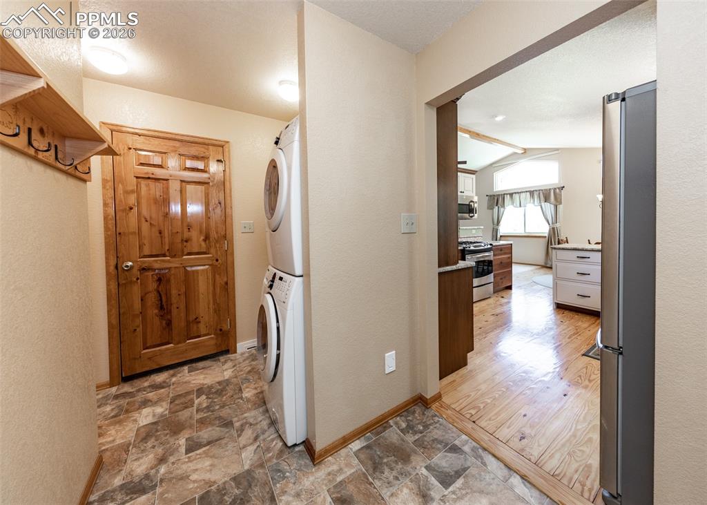 Image 23 of 50: View from garage door into laundry area and kitchen. Washer and dryer stay