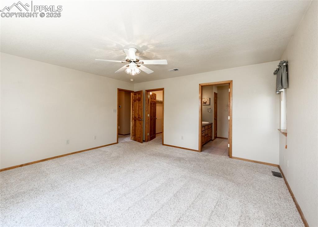 Image 25 of 50: The primary bedroom is generous and bright.