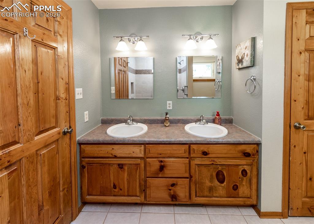 Image 28 of 50: Beautiful double vanity with warm wood accents and knotted pine doors.