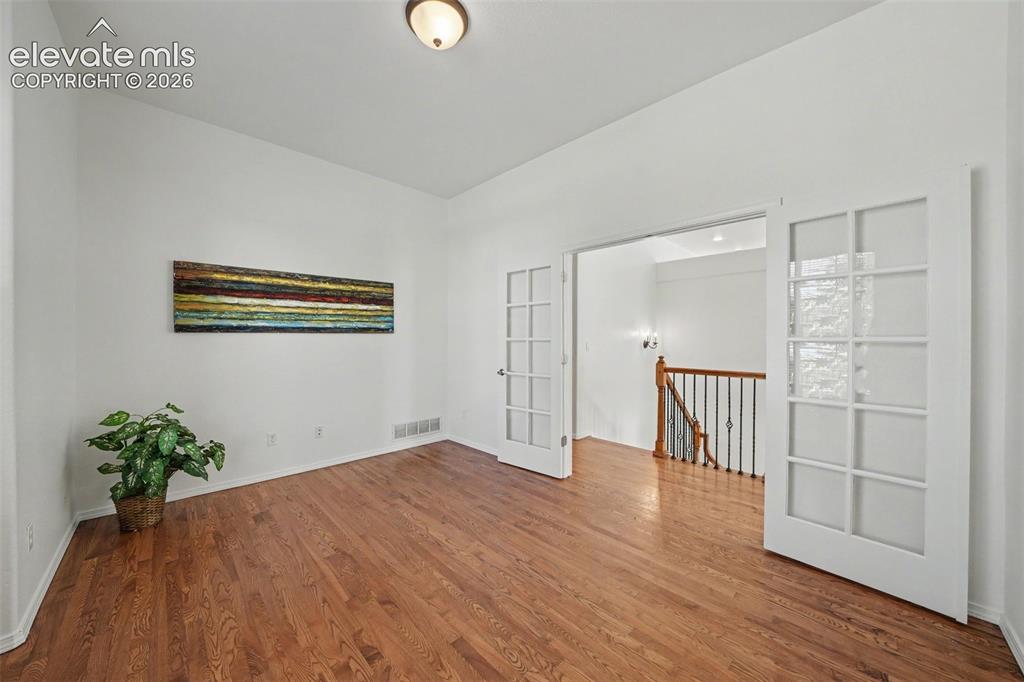Image 15 of 41: Glass French doors open to the main level office.