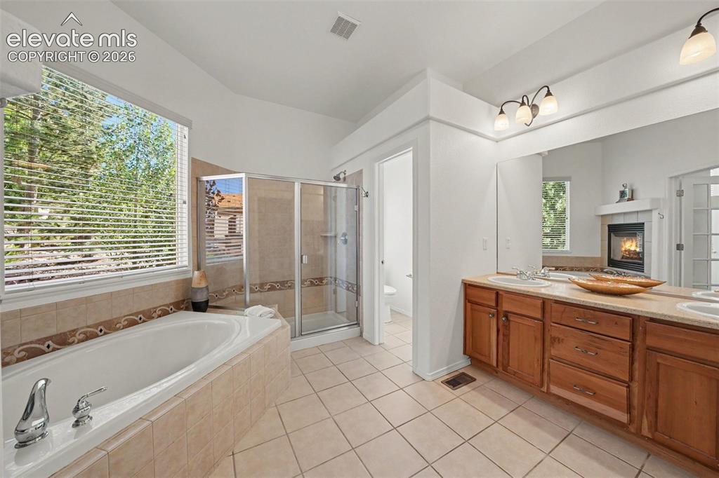 Image 20 of 41: Spacious five-piece primary bath with a double vanity and large walk-in sho
