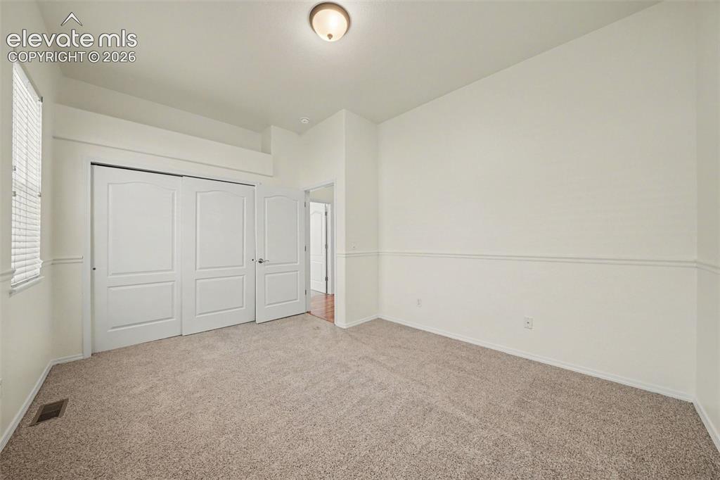 Image 24 of 41: Second main-level bedroom offers added flexibility for guests or everyday l