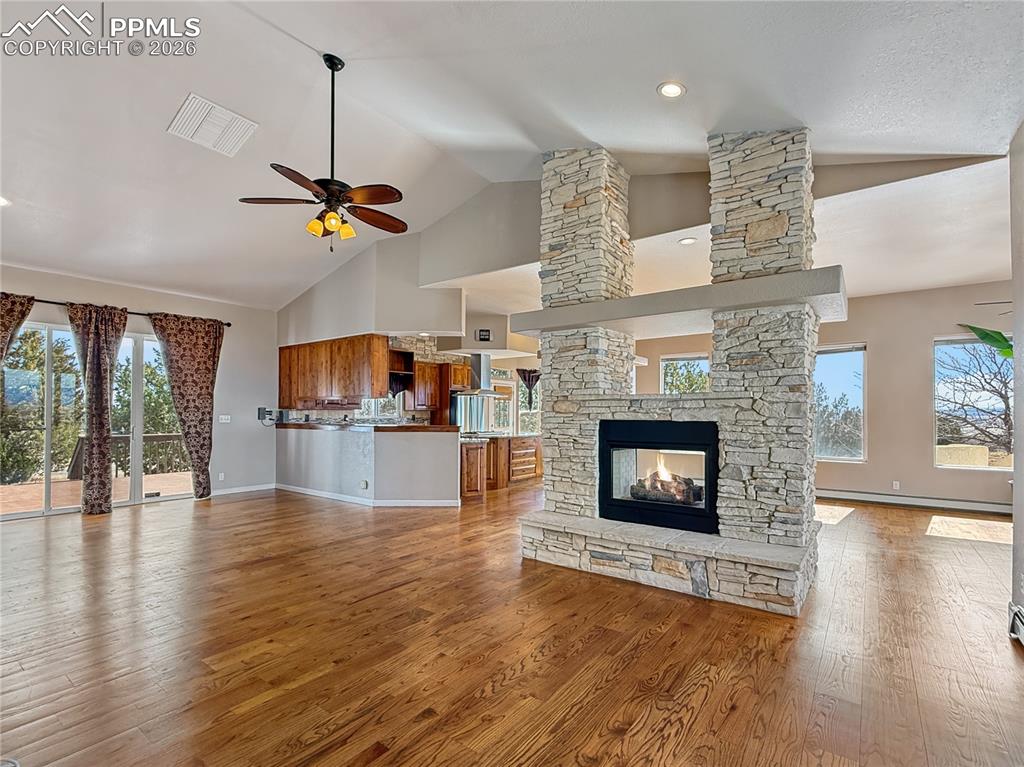 Image 8 of 50: Cozy fieplace and entrance to wide open deck for entertaining or relaxing