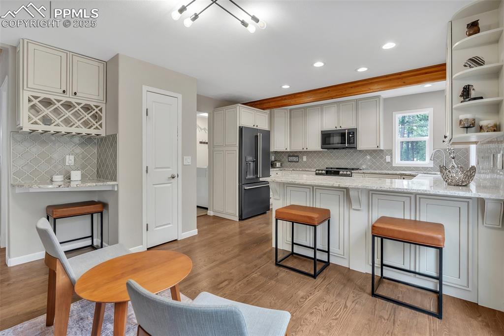 Image 14 of 50: Kitchen featuring backsplash, recessed lighting, high end refrigerator, ope