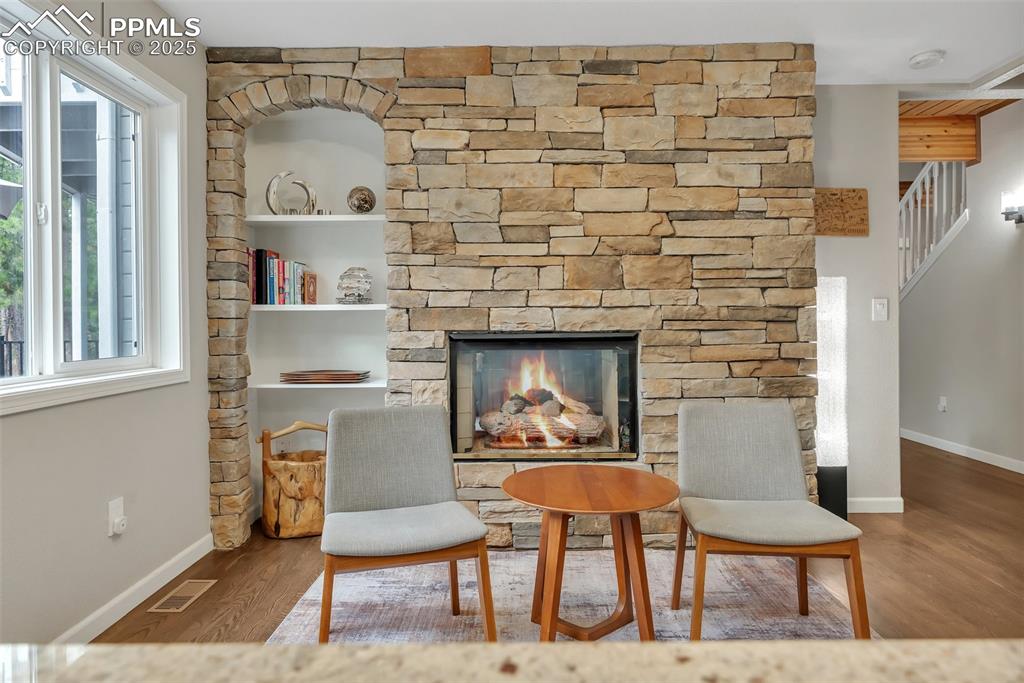 Image 16 of 50: Living area featuring wood finished floors and a stone fireplace