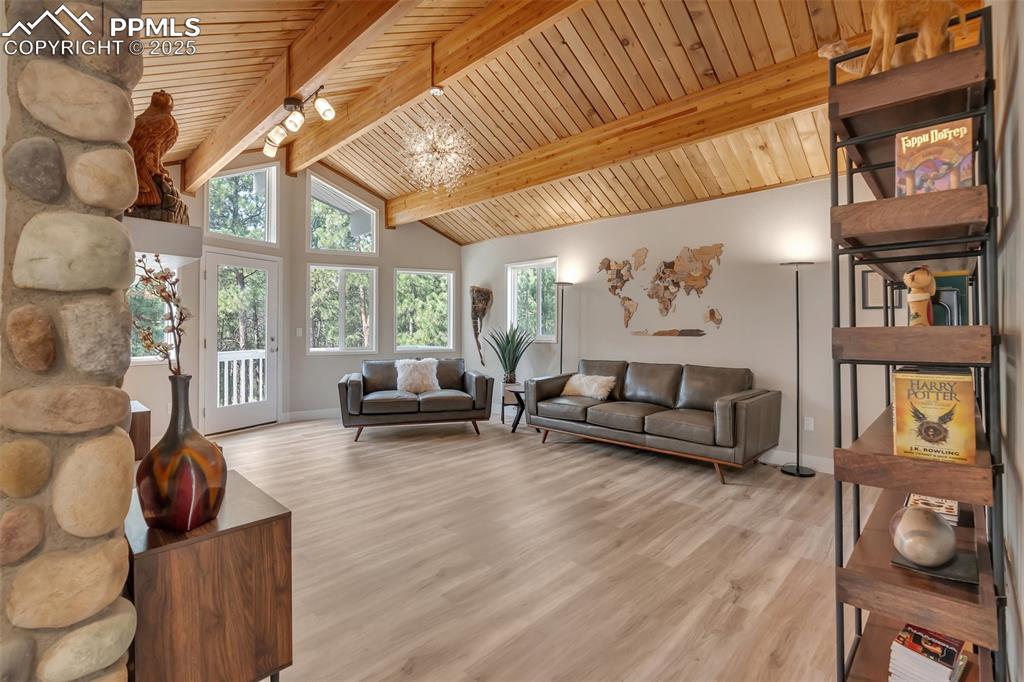 Image 26 of 50: Living room with wood finished floors, a chandelier, a wooden ceiling with 