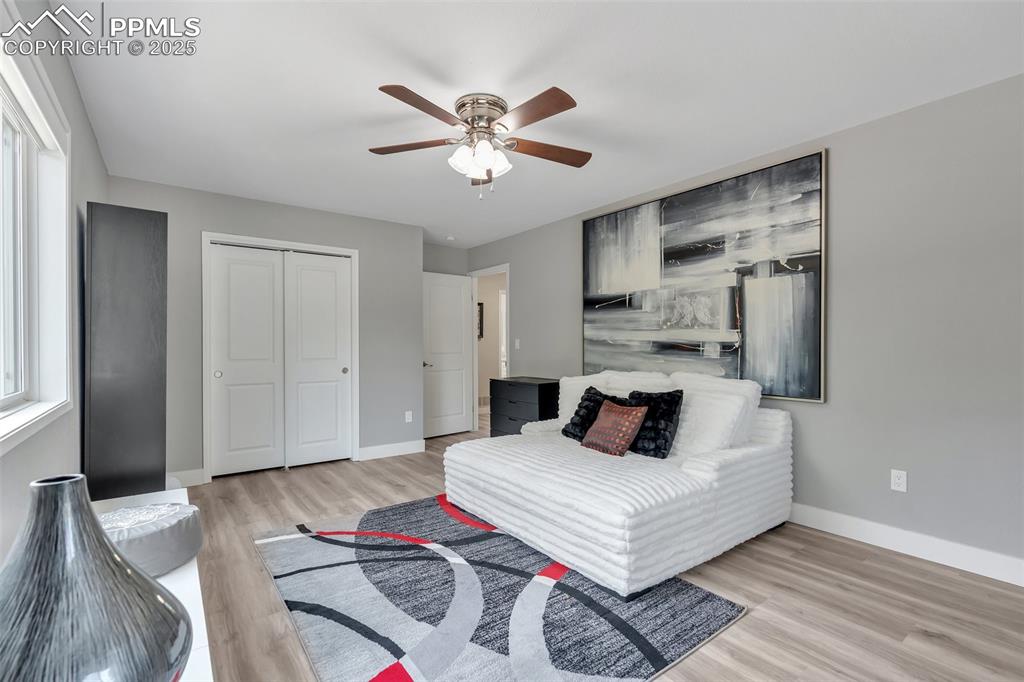 Image 28 of 50: Bedroom featuring light wood-style flooring, a closet, multiple windows, an