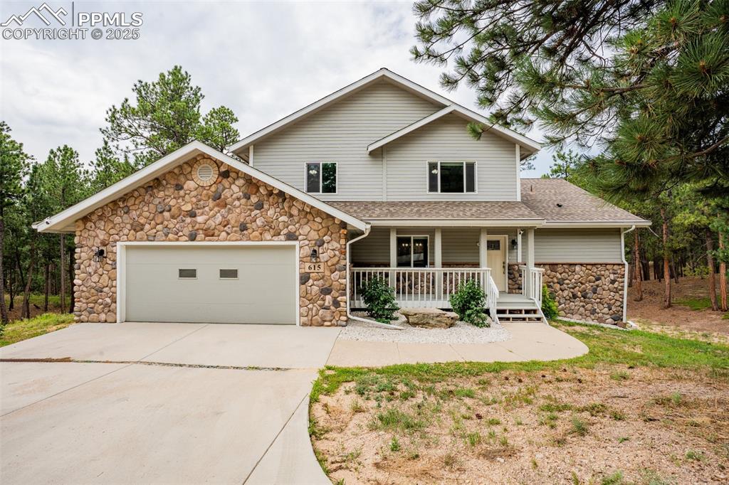 Image 3 of 50: View of front of house featuring covered porch, concrete driveway, and an a
