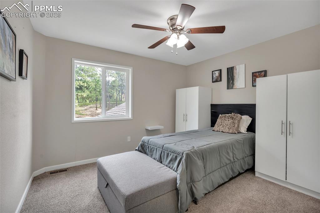 Image 30 of 50: Bedroom with light carpet and ceiling fan
