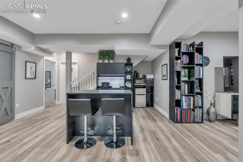 Image 35 of 50: Kitchen featuring light wood-style floors, fridge, a breakfast bar area, op