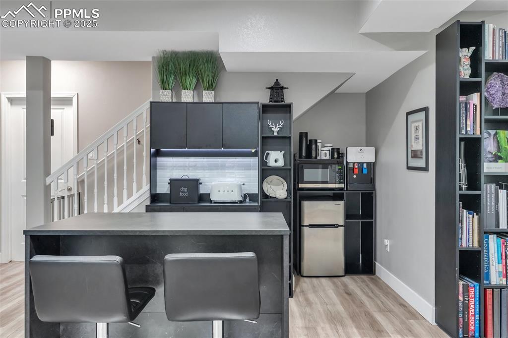 Image 36 of 50: Kitchen with open shelves, appliances with stainless steel finishes, light 