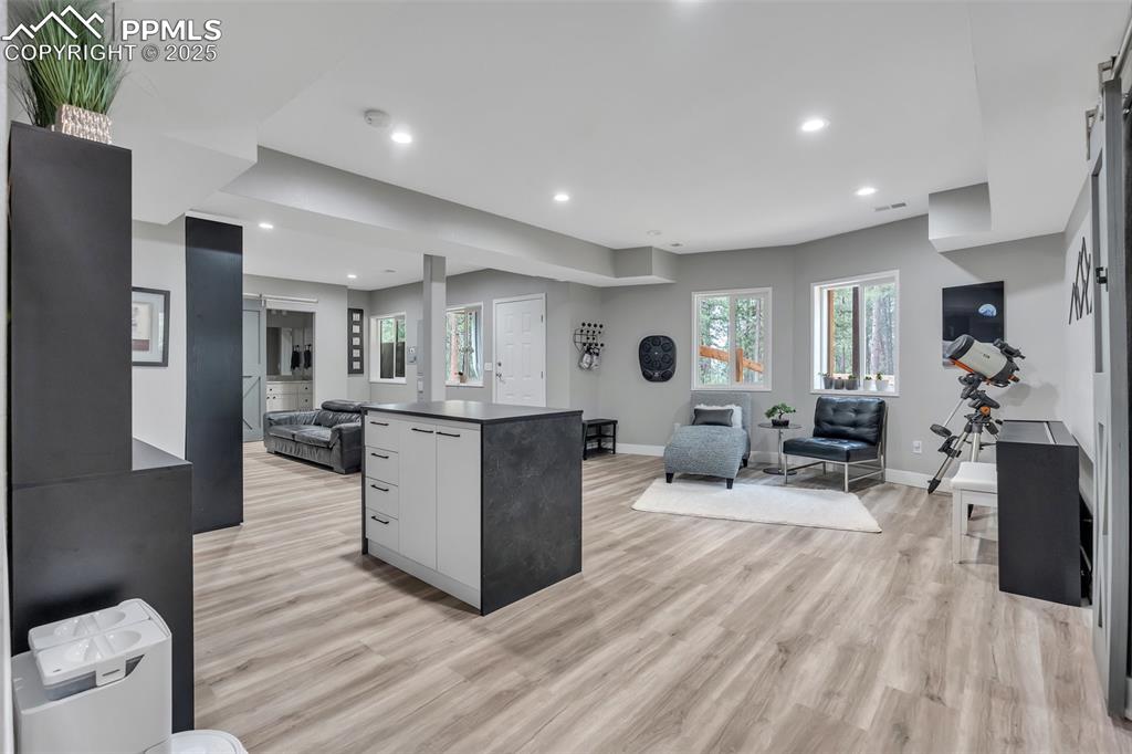 Image 37 of 50: Kitchen with open floor plan, dark countertops, healthy amount of natural l