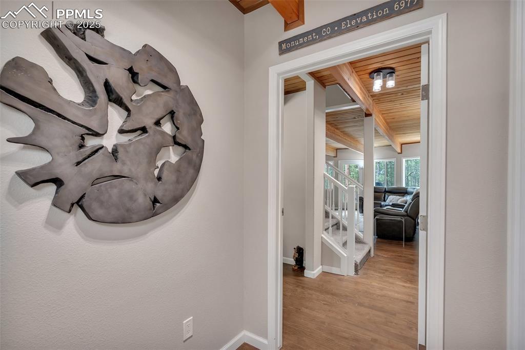 Image 4 of 50: Hall featuring stairs, wood finished floors, and a wood ceiling with expose