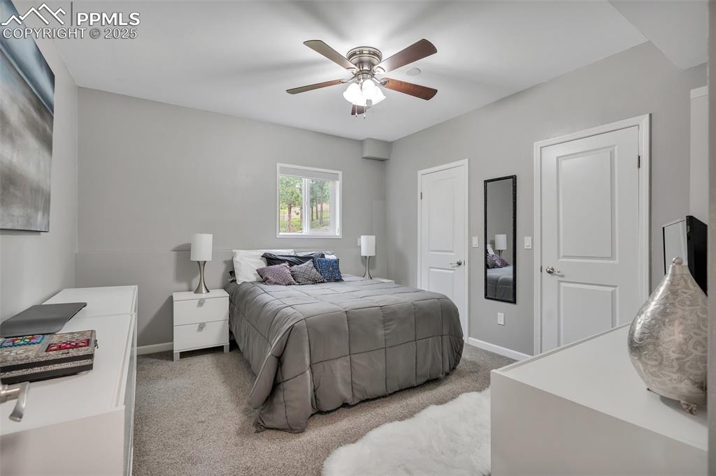 Image 40 of 50: Carpeted bedroom with baseboards and ceiling fan