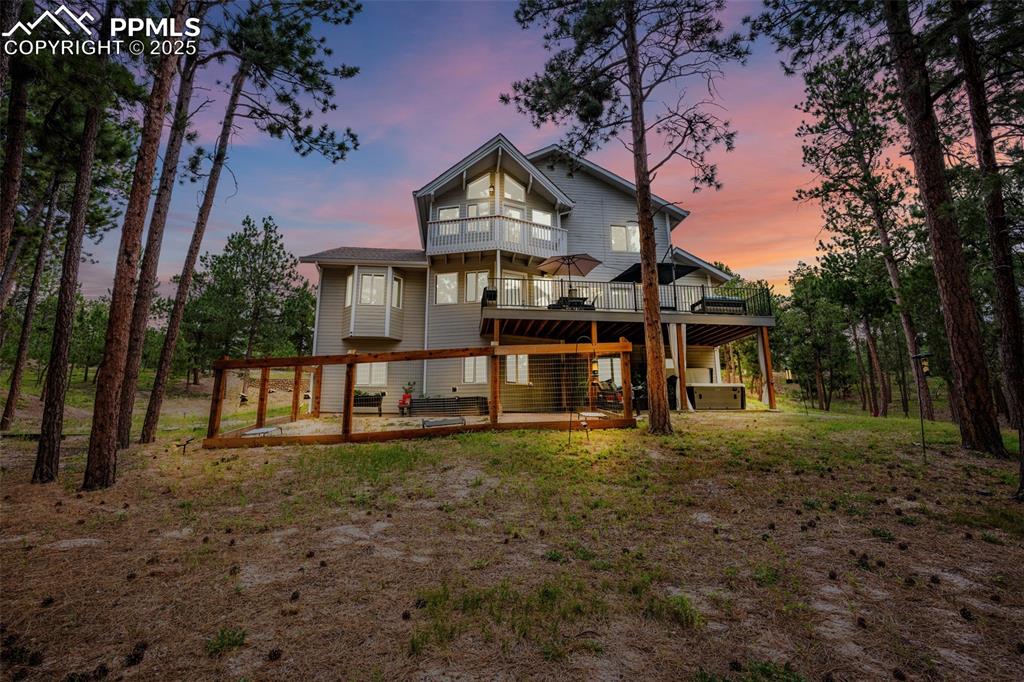 Image 48 of 50: Back of property at dusk with a deck and a patio area