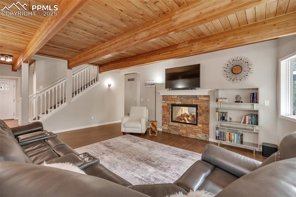 Image 7 of 50: Living area with plenty of natural light, a wood ceiling with exposed beams