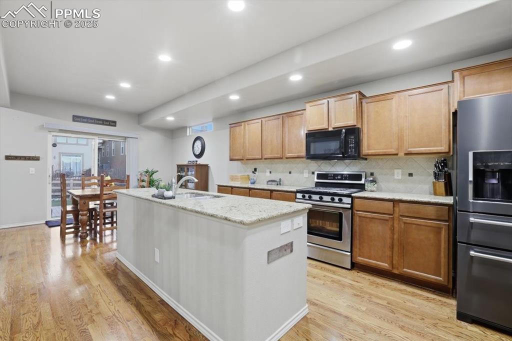 Image 10 of 50: The kitchen has lots of can lights and natural lighting from the sliding gl