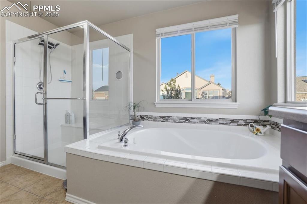 Image 25 of 50: The primary bath has a large shower and a separate soaking tub with private