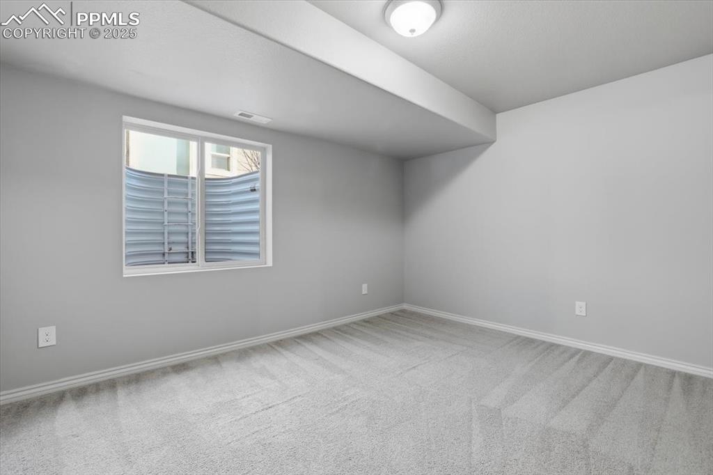 Image 43 of 50: This basement-level bedroom gets lots of light from the double window and a