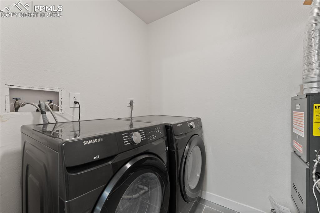 Image 16 of 16: Laundry room with washer and clothes dryer and heating unit