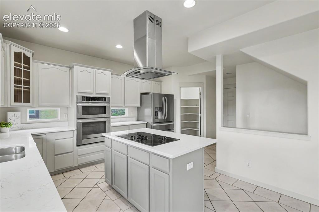 Image 11 of 47: Modern kitchen featuring light gray cabinetry, stainless steel appliances,