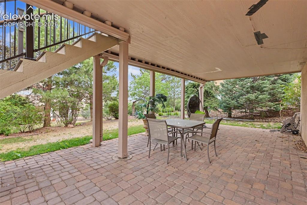Image 14 of 47: Covered outdoor patio featuring brick paver flooring, structural support co