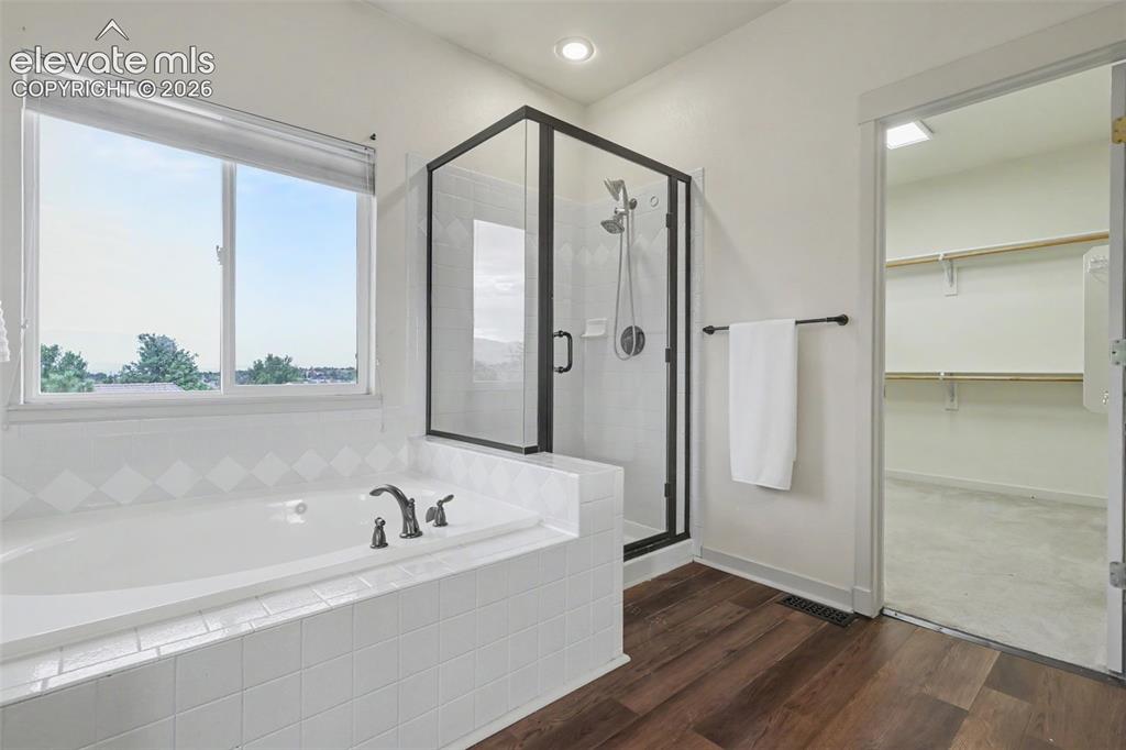 Image 21 of 47: Bathroom featuring a built-in soaking tub with white tile surround, a glass