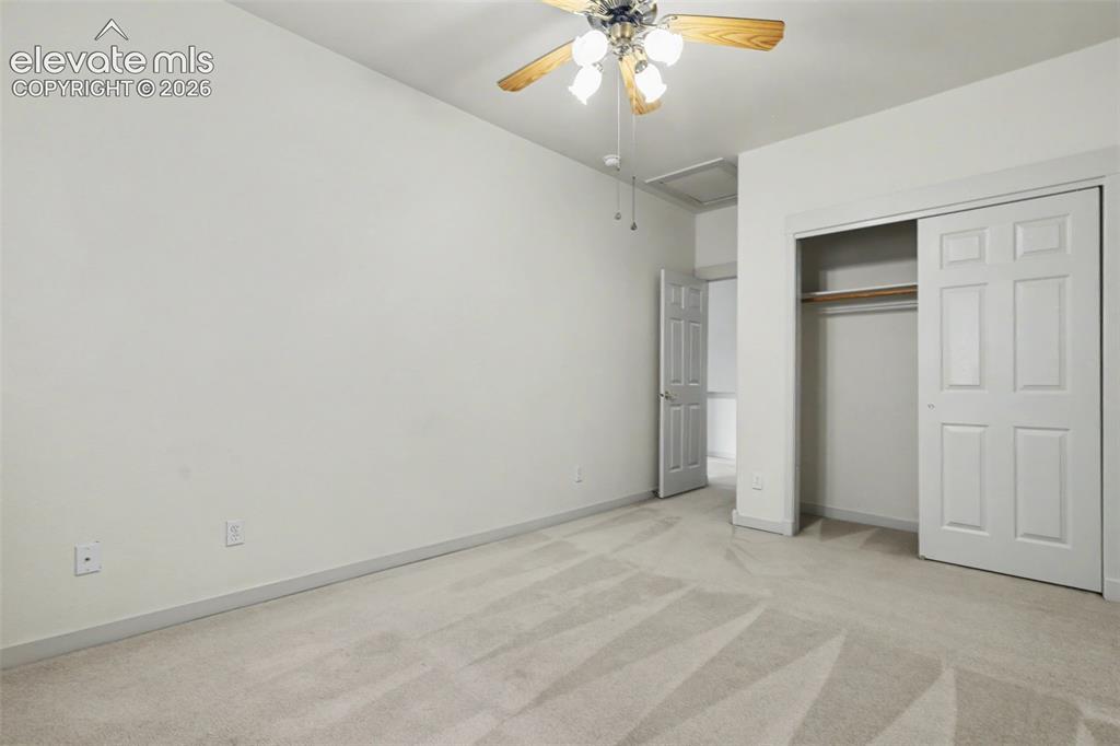 Image 23 of 47: Carpeted room featuring a ceiling fan with light fixture, neutral wall pain