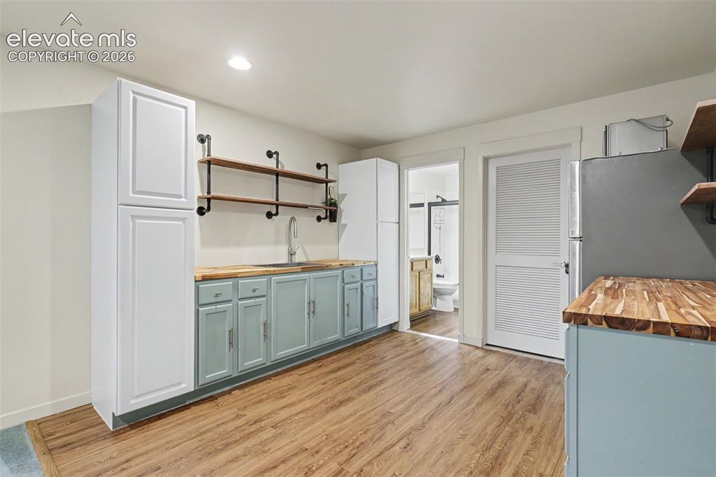 Image 28 of 47: Full kitchen-style setup featuring a wood-finish floor and white walls
