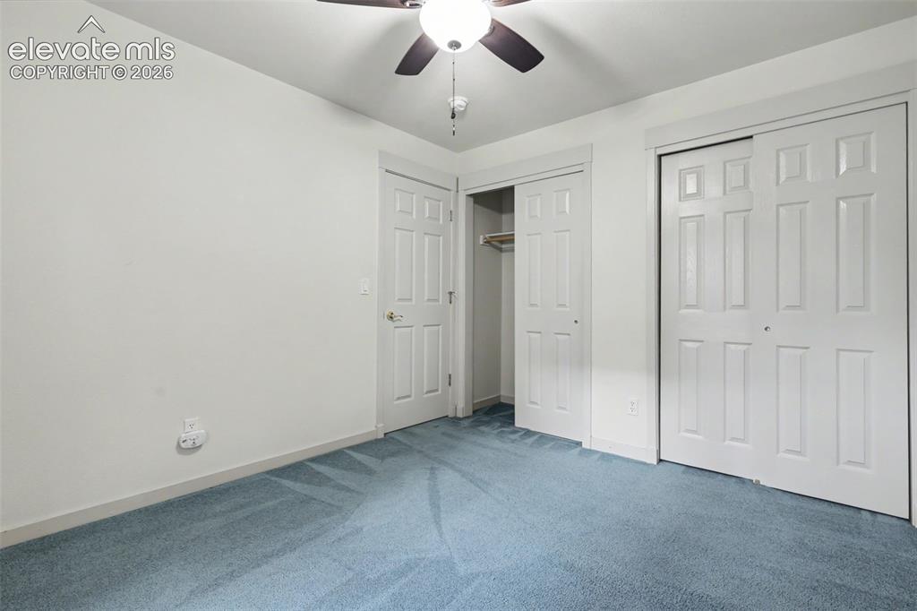 Image 31 of 47: Bedroom featuring light blue carpeting, white walls, and a ceiling fan with