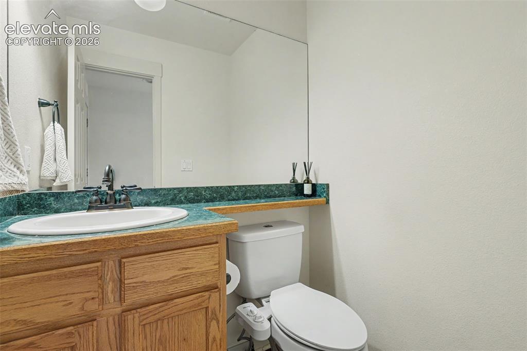 Image 33 of 47: Bathroom featuring a vanity with a white oval sink, wood-finish cabinetry,