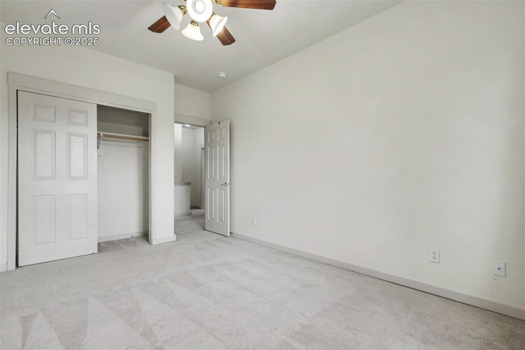Image 35 of 47: Carpeted room featuring a ceiling fan with integrated lighting, a closet wi
