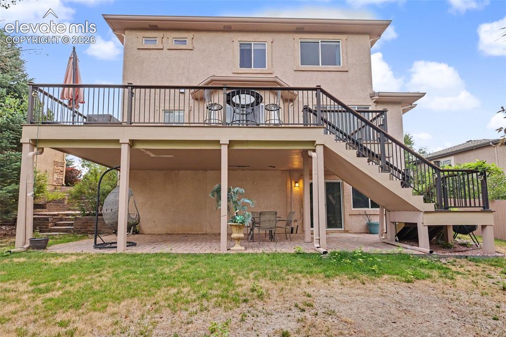 Image 41 of 47: Two-story stucco exterior featuring an elevated deck with black railings an