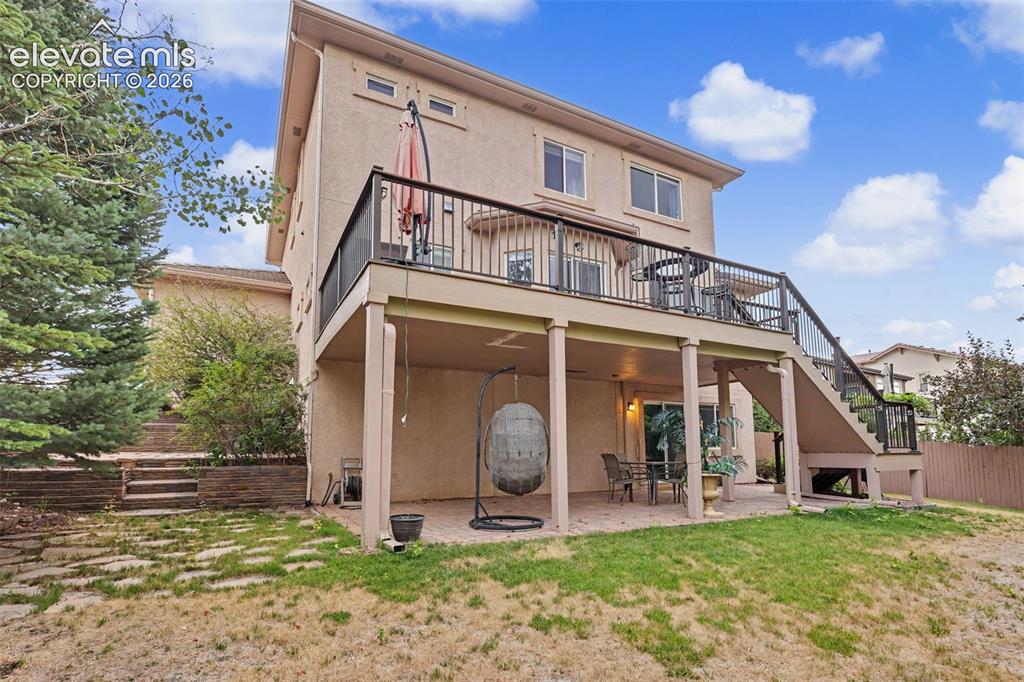 Image 42 of 47: Rear exterior featuring a two-story design with a stucco finish