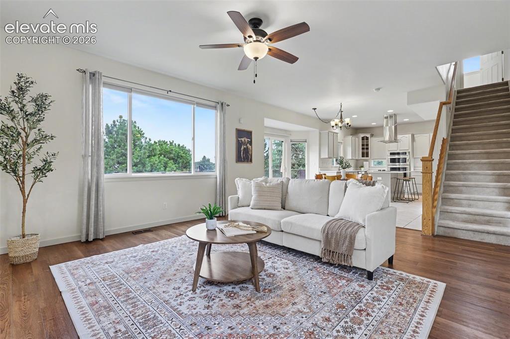 Image 5 of 47: Open-concept living space featuring wood-finish flooring, a large picture w