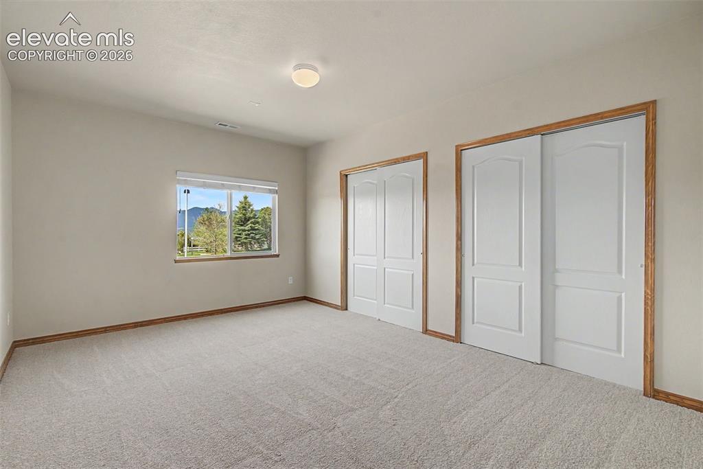 Image 37 of 50: Basement bedroom with mountain views